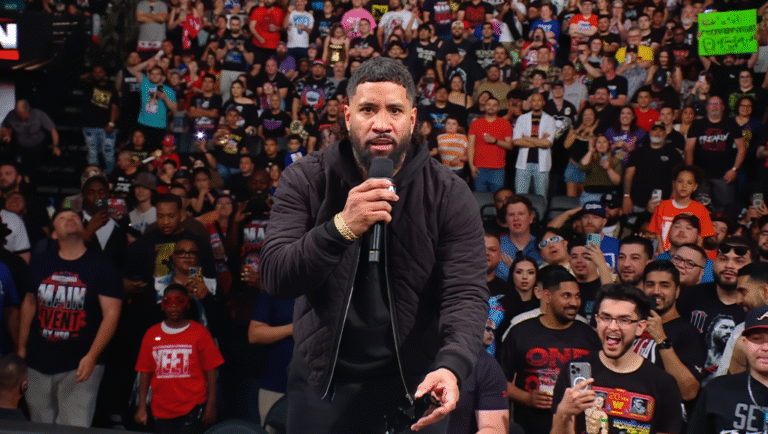 a man holding a microphone in front of a crowd